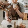 A woman crafting candles in a rustic workshop, focusing on scents and quality.
