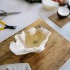 Handmade sea shell candle on wooden board, showcasing a unique crafting process.