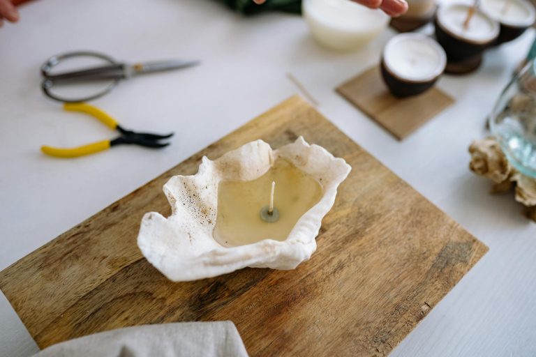 Handmade sea shell candle on wooden board, showcasing a unique crafting process.